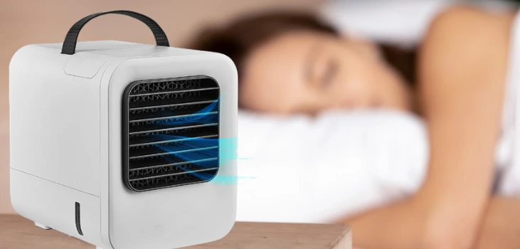 woman sleeping with chiller portable ac by her side