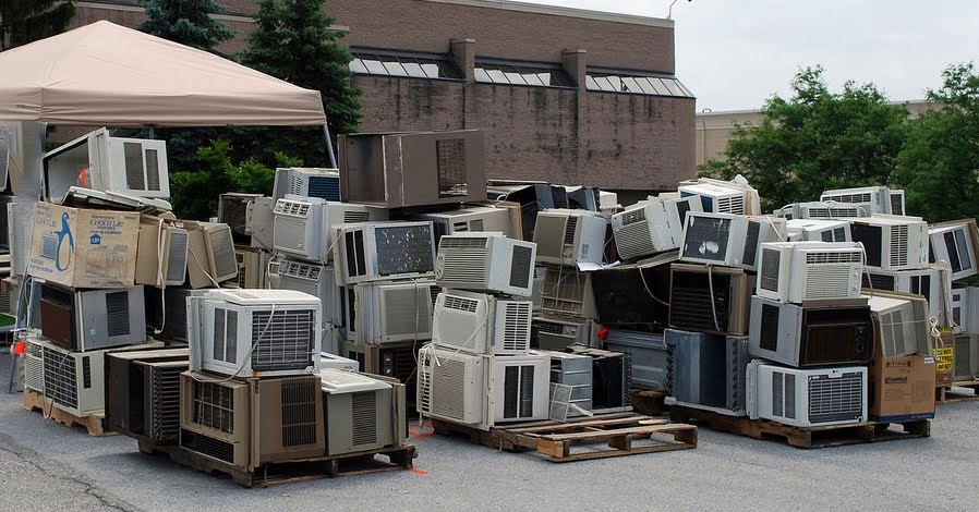 a yard full of broken and abandoned ac units